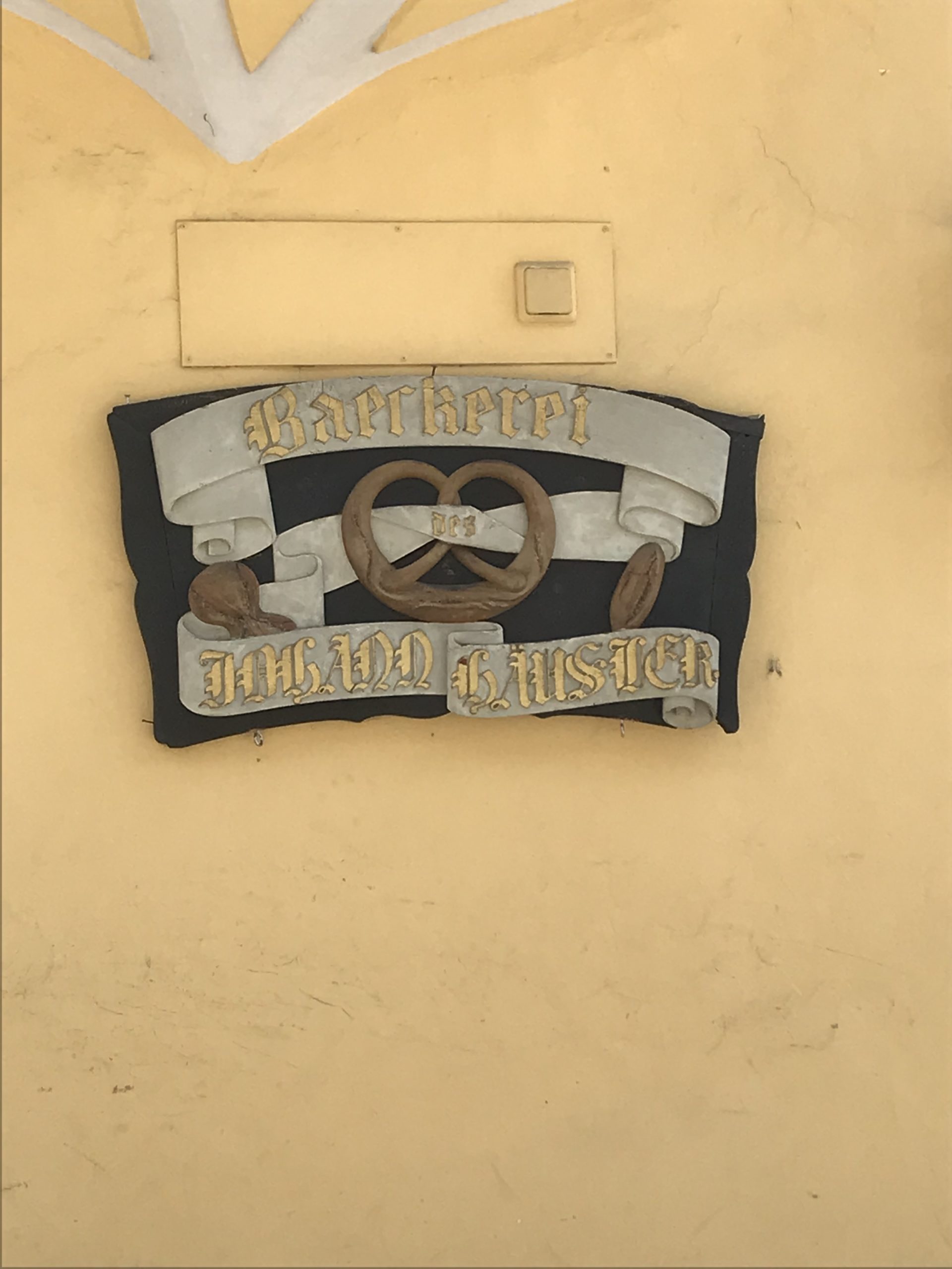 Das Zeichen des Bäckers an der Hauswand, in Form einer Brezel 