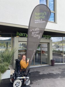 Ich halte die Fahne von Harrys Home in den Händen vor dem Eingang